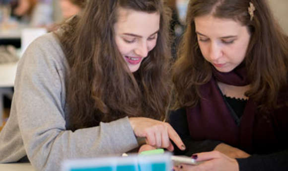 A pair of ϲ students working together using a mobile app