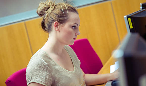 A ϲ student working alone at their computer desk, Edinburgh