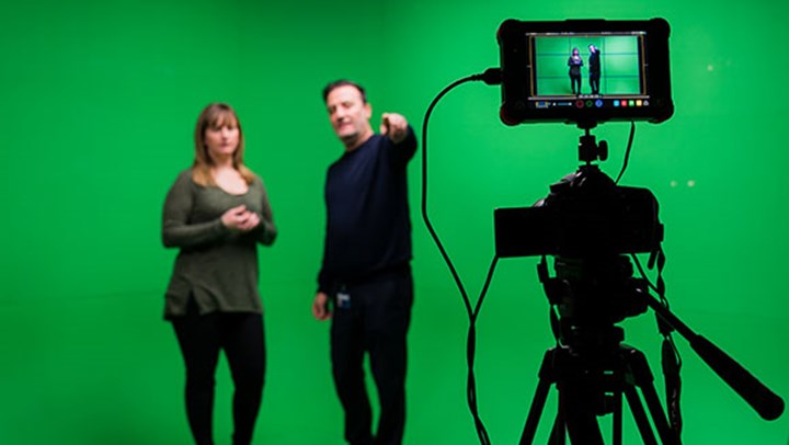 A ϲ student being briefed in front of a green screen